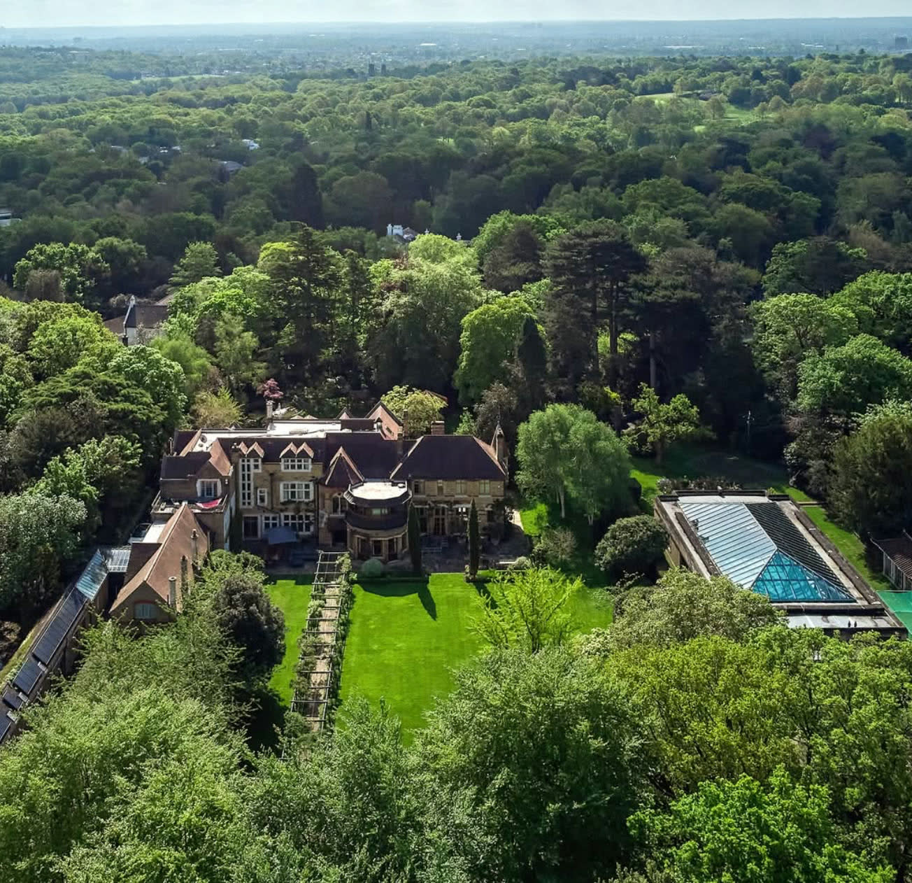Holmwood from above, the home and its glass-roofed pool house set among the trees beside Richmond Park