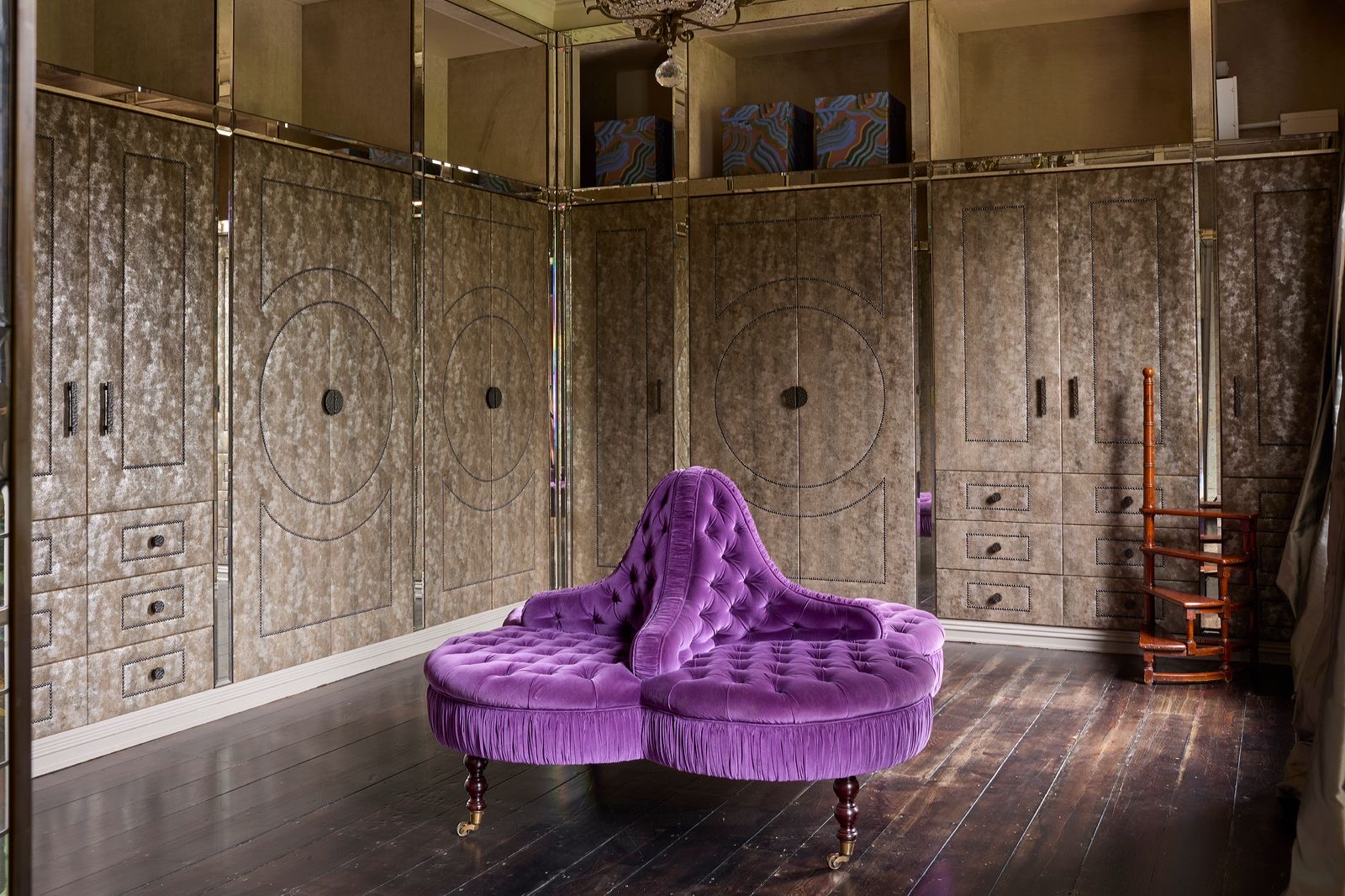 A dressing room with a purple velvet seat