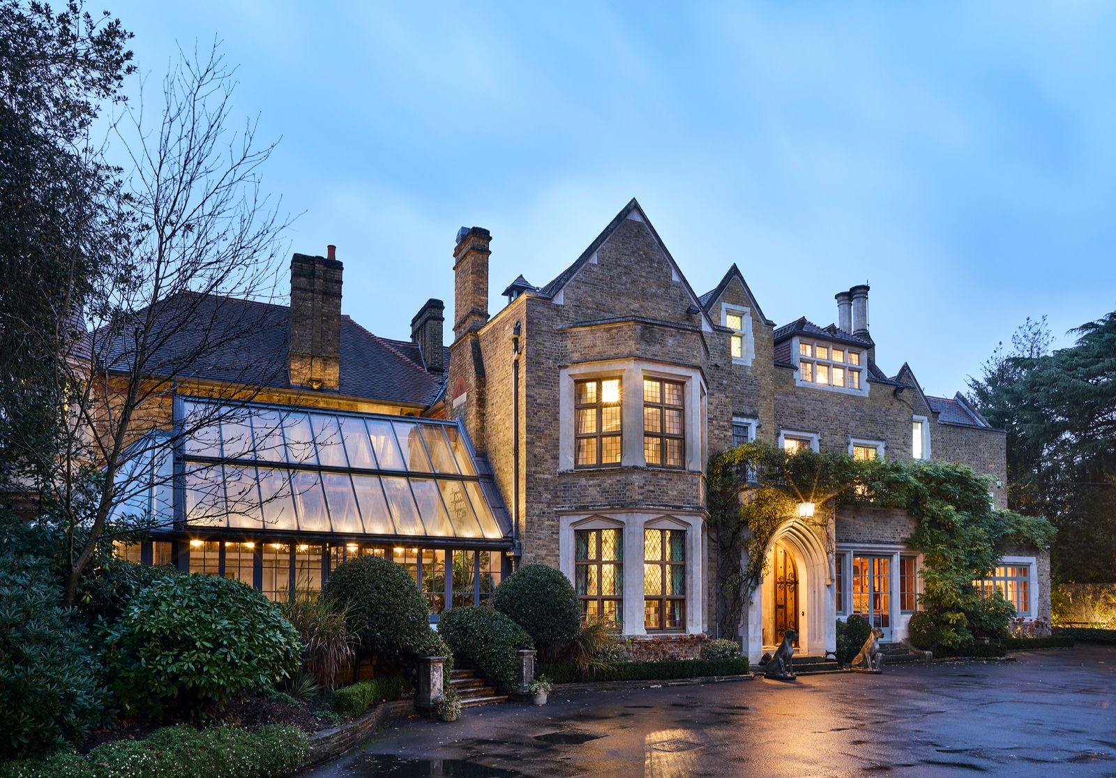 The front of the home and conservatory lit at dusk