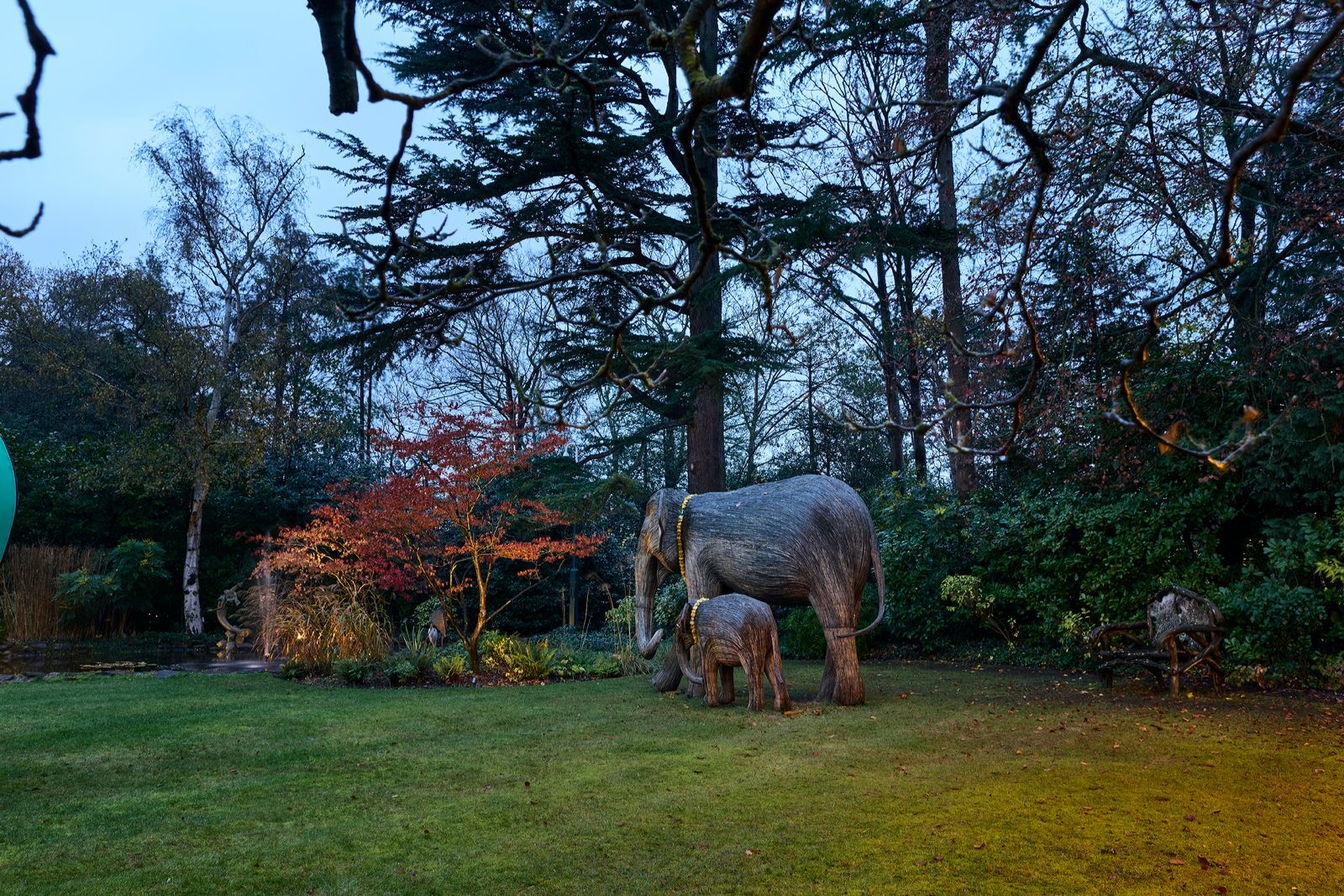 Elephant sculptures on the lawn at dusk