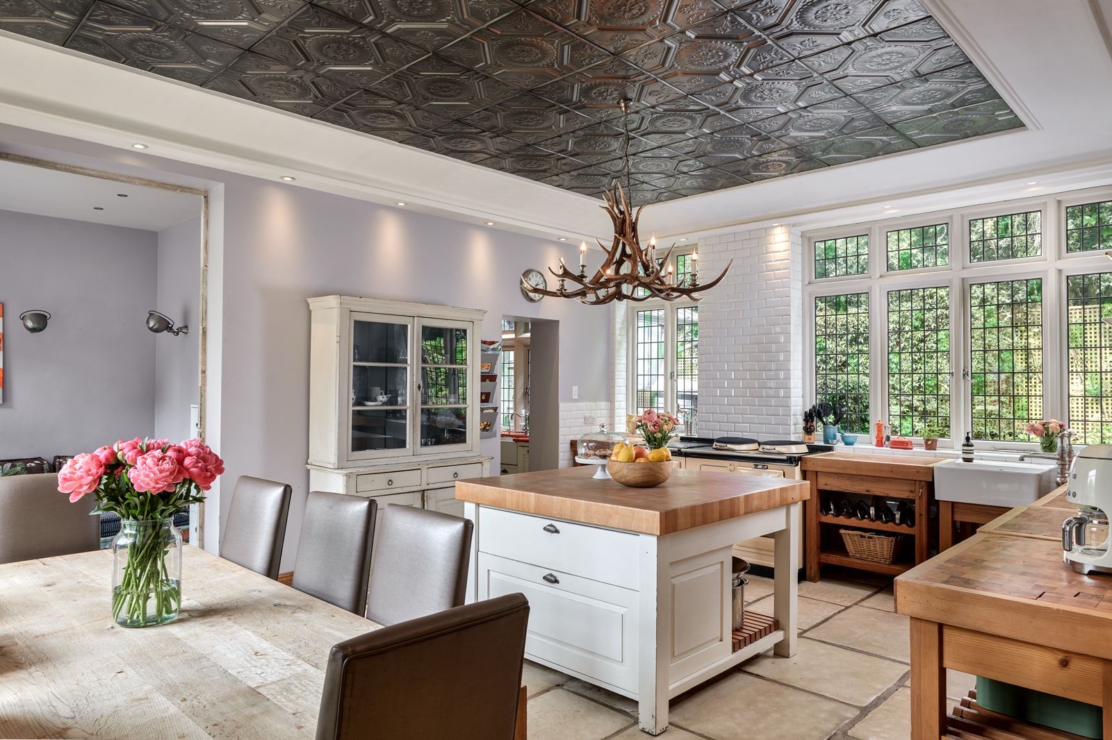 A white kitchen with an island and a long table