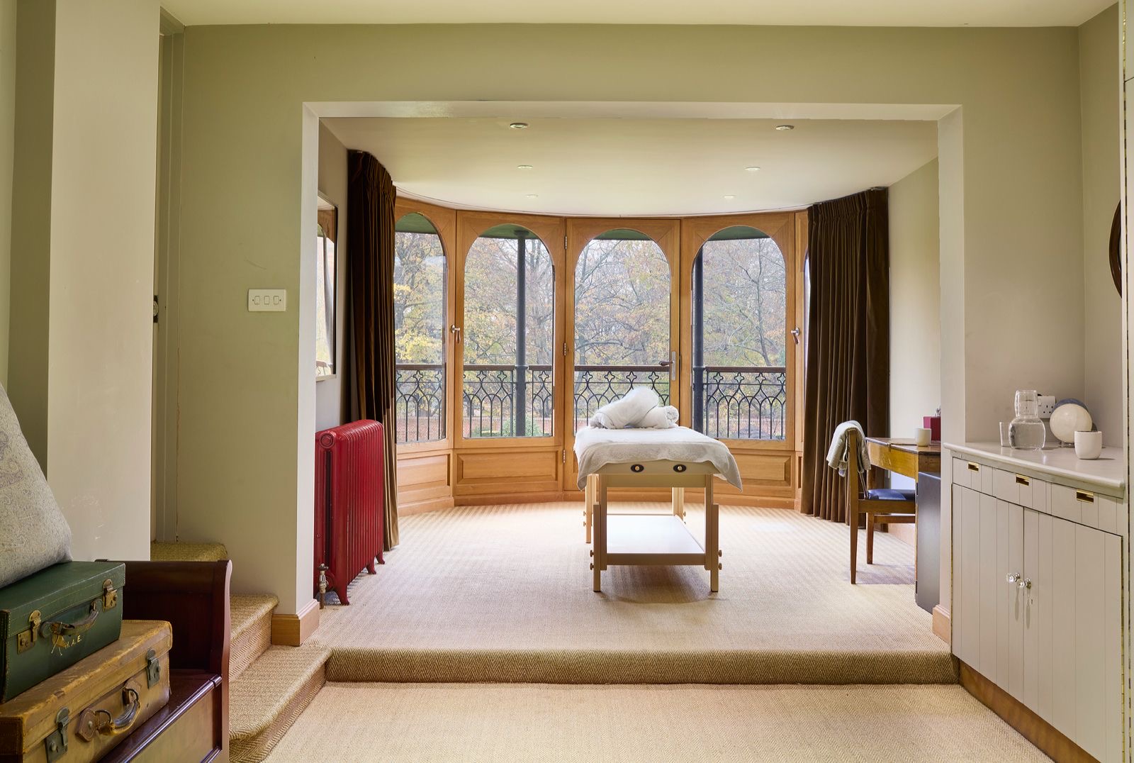 The treatment room, a massage table in a bay window onto the trees