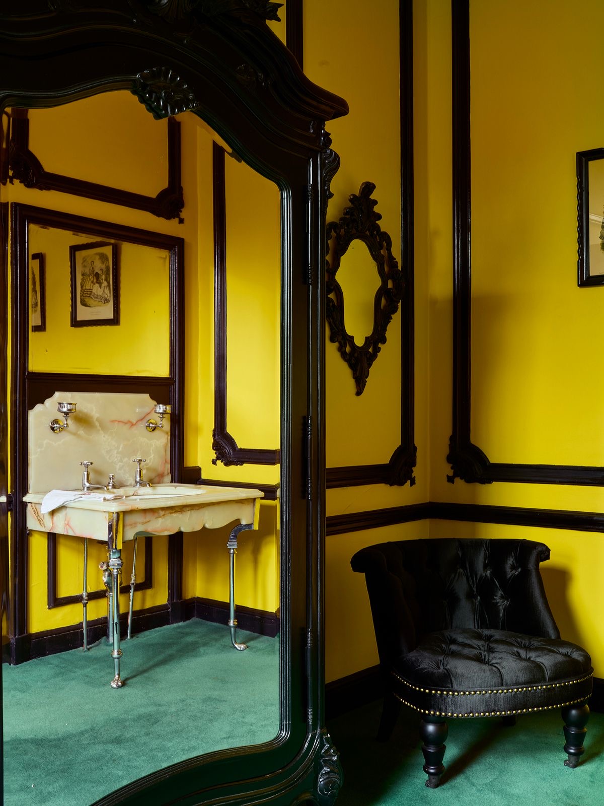 A yellow room with a gilded mirror